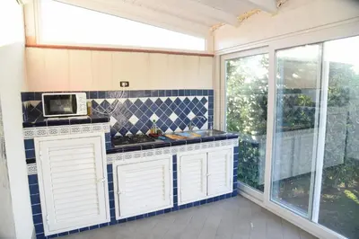 a kitchen with white cabinets and a microwave at Villa Letizia in Campofelice di Roccella