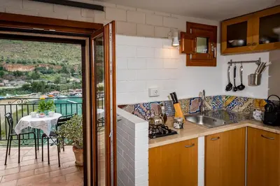 a kitchen with a view of a balcony with a table at Veranda sul Porticciolo in Castellammare del Golfo