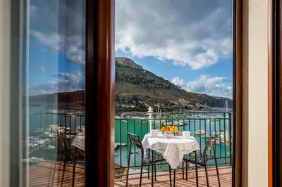 a balcony with a table and a view of the water at Veranda sul Porticciolo in Castellammare del Golfo
