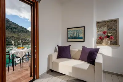 a living room with a couch and a balcony at Veranda sul Porticciolo in Castellammare del Golfo