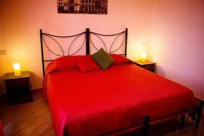 a bedroom with a red bed with two lights on it at Antadia in Palermo