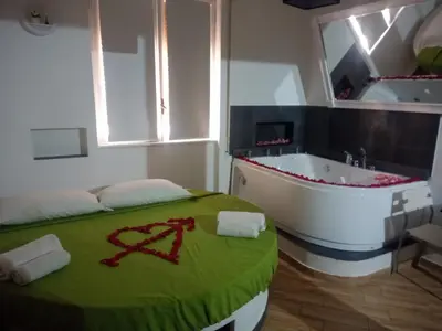 a room with a tub and a bed with a green blanket at Antadia in Palermo