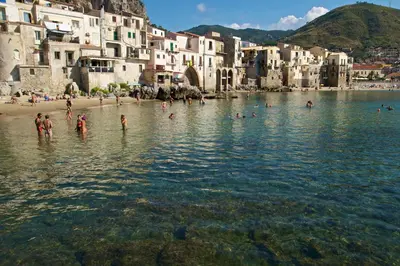 a group of people in the water at a beach at Antadia in Palermo