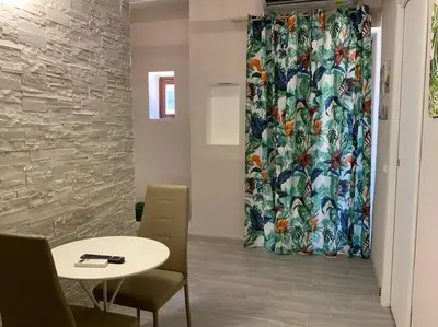 a table and chairs and a curtain in a room at Demma' s DIAMOND in Palermo