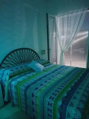 a bedroom with a bed with a blanket and a window at Pensiero Speciale in Alcamo