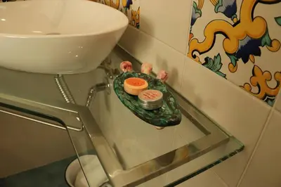 a bathroom with a sink and a plate with sushi at Pensiero Speciale in Alcamo