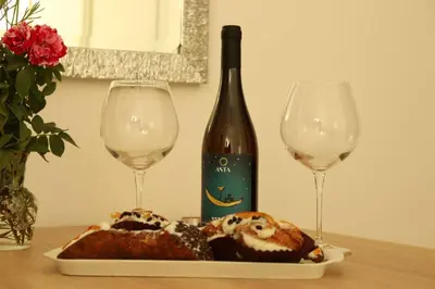 a bottle of wine and a plate of food and two glasses at Pensiero Speciale in Alcamo