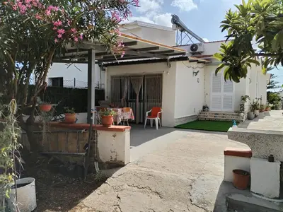 a white house with a patio with pink flowers at Pensiero Speciale in Alcamo