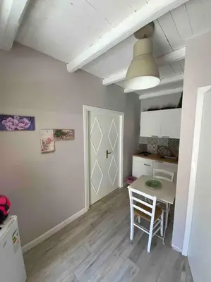 a room with a table and a kitchen with a door at Spasimo Boutique in Palermo