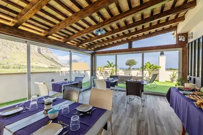 a dining room with a view of the water at B&B L'Angolino della nonna in Castelluzzo