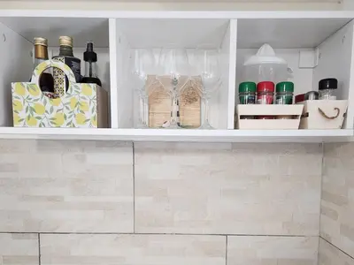 a shelf with wine bottles and other items in a kitchen at Don Vito's Home, DsG2 Short Lets, 250 mt Metrò in Palermo