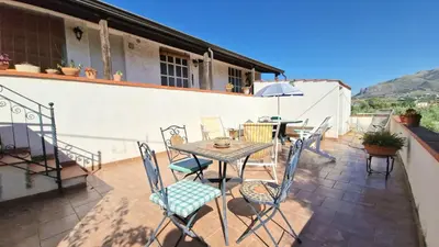 a patio with a table and chairs on a roof at Appartamenti Amagea in Scopello