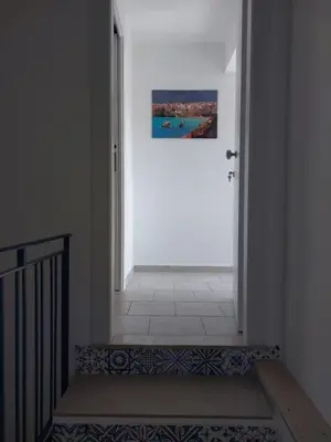 a hallway with an open door with a picture on the wall at Levante in Terrasini