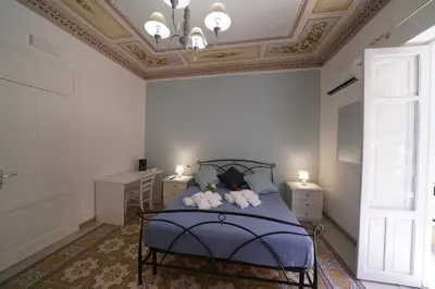 a bedroom with a blue bed with a coffered ceiling at Regina Stella in Lascari