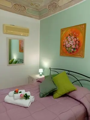 a bedroom with a purple bed with two towels on it at Regina Stella in Lascari