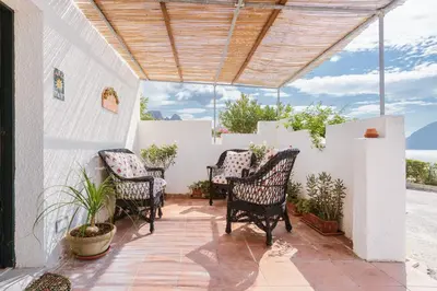 a patio with four chairs and a wooden ceiling at Isulidda Gaia Mare in San Vito lo Capo