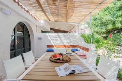 a wooden table with a bowl of fruit and a book at Isulidda Gaia Mare in San Vito lo Capo
