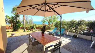 a wooden table with an umbrella on a patio at Casa di Pino in Cefalù