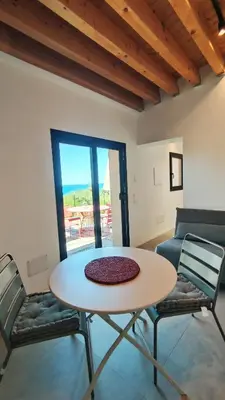 a table and chairs in a room with a patio at Casa di Pino in Cefalù