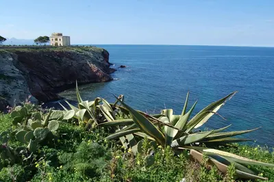 a house on top of a cliff next to the ocean at Cinisi 89 B&B in Cinisi