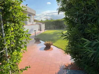 a garden with a brick walkway between two bushes at Villa Capri Holiday Home in Campofelice di Roccella