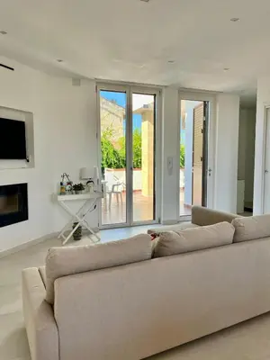 a living room with a couch and a television at Villa Capri Holiday Home in Campofelice di Roccella