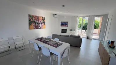 a living room with a white table and chairs at Villa Capri Holiday Home in Campofelice di Roccella