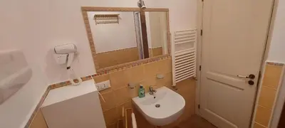 a small bathroom with a sink and a mirror at Casetta di Ale al Capo in Palermo