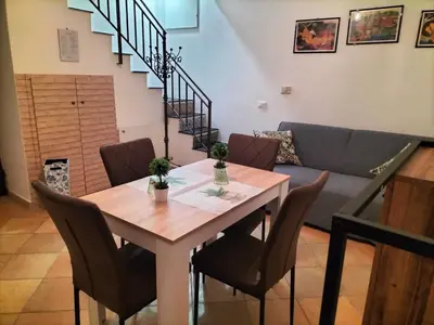 a table and chairs in a living room with a couch at Casetta di Ale al Capo in Palermo