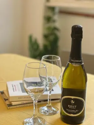 a bottle of wine and two wine glasses on a table at casa vacanze Mondello mare piscina CHIFEVI in Mondello