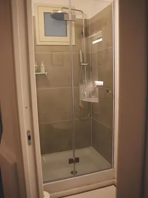 a shower with a glass door in a bathroom at Il corvo e la volpe in Palermo