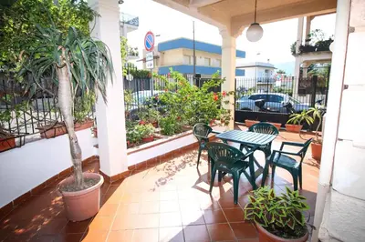 a patio with a table and chairs and a palm tree at Il Gelsomino in Palermo