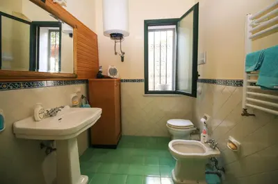 a bathroom with a sink and a toilet and a mirror at Il Gelsomino in Palermo