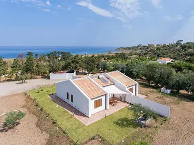an aerial view of a white house with the ocean in the background at Villa Beba in Cefalù