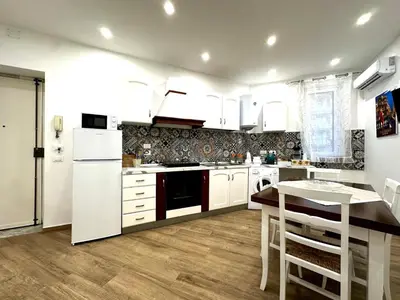 a kitchen with white appliances and a wooden floor at MD APARTAMENT CORAL BAHLARA in Palermo