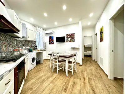 a kitchen and dining room with a table and chairs at MD APARTAMENT CORAL BAHLARA in Palermo