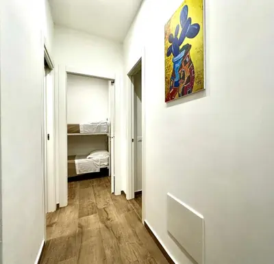 a hallway with a room with a bed and a painting on the wall at MD APARTAMENT CORAL BAHLARA in Palermo
