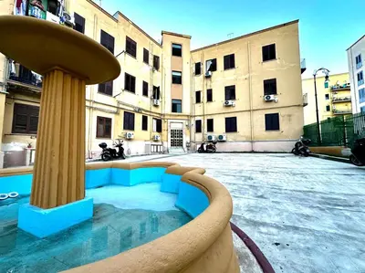 a building with a fountain in the middle of a courtyard at MD APARTAMENT CORAL BAHLARA in Palermo