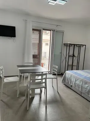 a bedroom with a table and chairs and a bed at Summer Vibes in Castellammare del Golfo