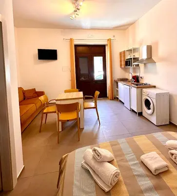 a living room with a couch and a table with towels at Summer Vibes in Castellammare del Golfo