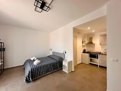 a bedroom with a bed and a small kitchen at Summer Vibes in Castellammare del Golfo