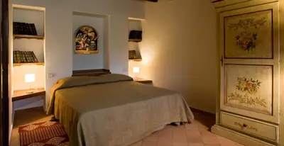 a bedroom with a bed and two tables and lamps at Casa Margaret in Collesano