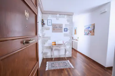 a bathroom with a sink and a wooden door at Stupor Mundi Bed and Breakfast in Palermo