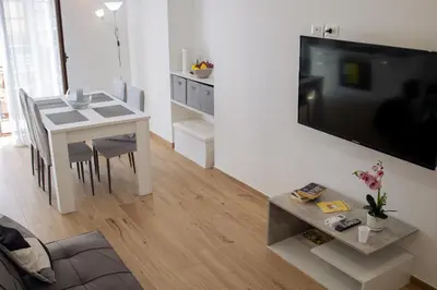 a living room with a table and a large television at La Casa al mercato - SELF CHECK-IN in Palermo