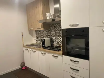 a kitchen with white cabinets and a black oven at Nigra Apartments in Palermo