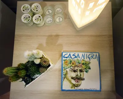 a table with a book and a picture of a man with flowers at Nigra Apartments in Palermo