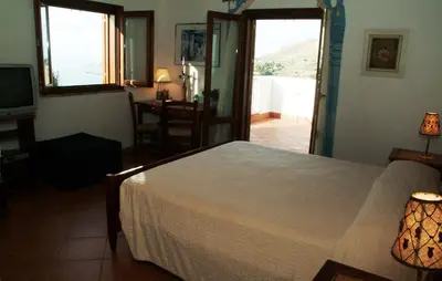 a bedroom with a bed and a view of a balcony at Punto de Vista B&B Makari in San Vito lo Capo