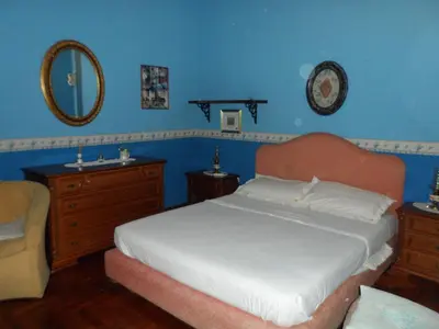 a bedroom with a bed and a mirror and a chair at Alle Terrazze del Borgo Vecchio in Palermo