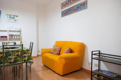 a yellow couch with two pillows on it in a room at Appartamento nel centro storico di Palermo - Via Meli's House in Palermo