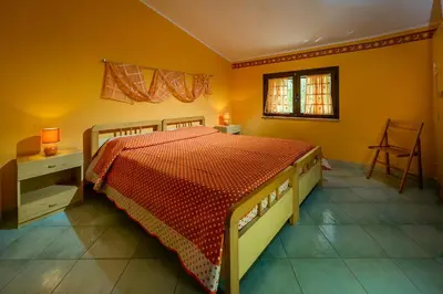 a bedroom with a bed and a table and a window at Villa Oasi del Relax Flavianna in Castellammare del Golfo